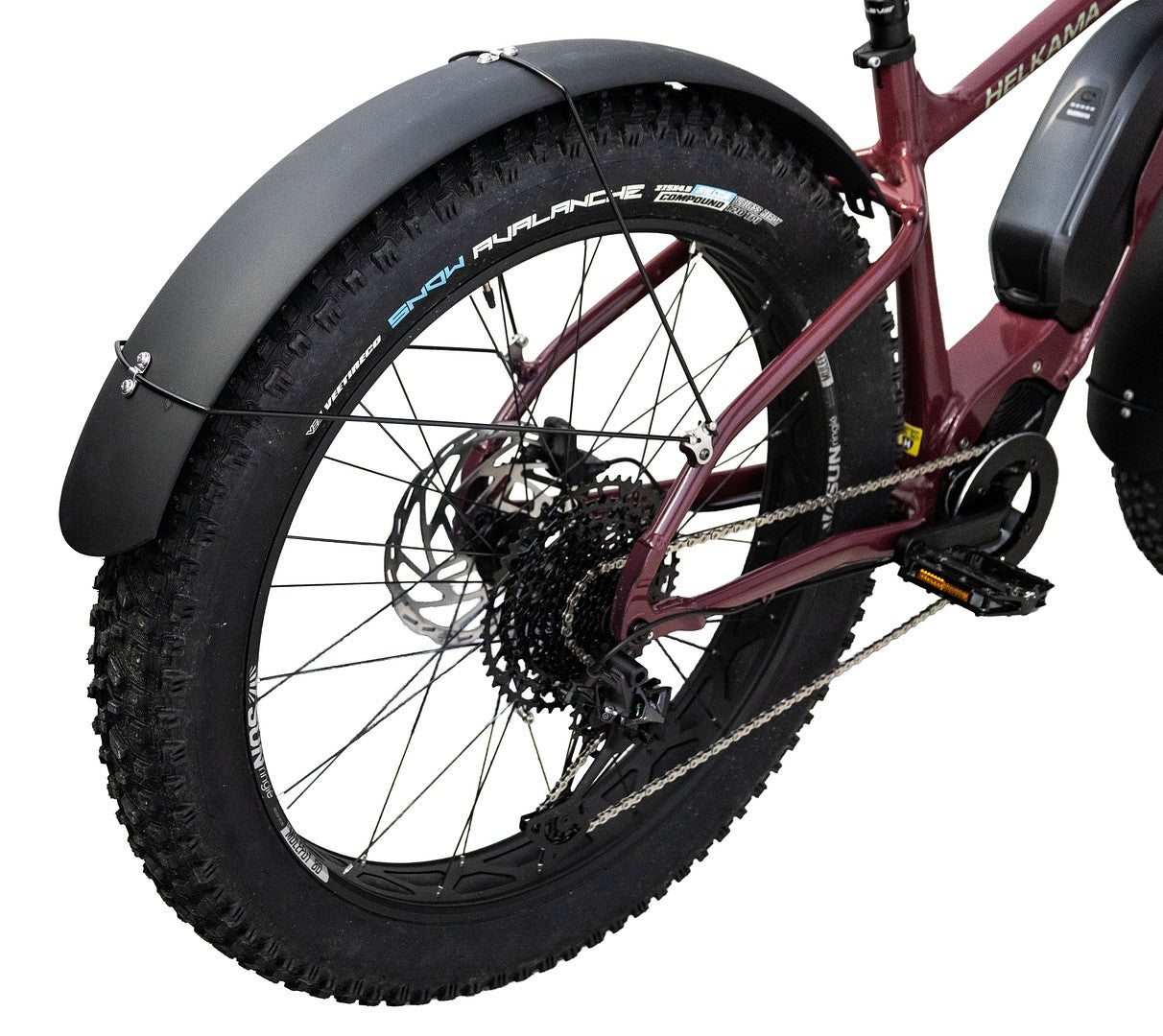 Lähikuva ruskeankeltaisen Helkama-läskipyörän takaosasta, jossa näkyy paksu kulutuspintainen rengas, vaihteet, ketju, musta poljin ja pyörän peittävä kaareva HELKAMA: FATBIKE LOKASUOJASETTI ETEEN JA TAAKSE -lokasuoja.