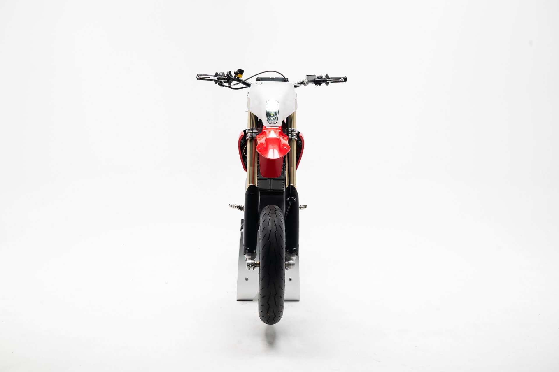 Stark Varg SM *korkotarjous alkaen 1,99 %*, Stark, moderni supermoto-moottoripyörä, jossa on punavalkoinen runko, kultaiset etuhaarukat ja musta eturengas, etukuva valkoista taustaa vasten.