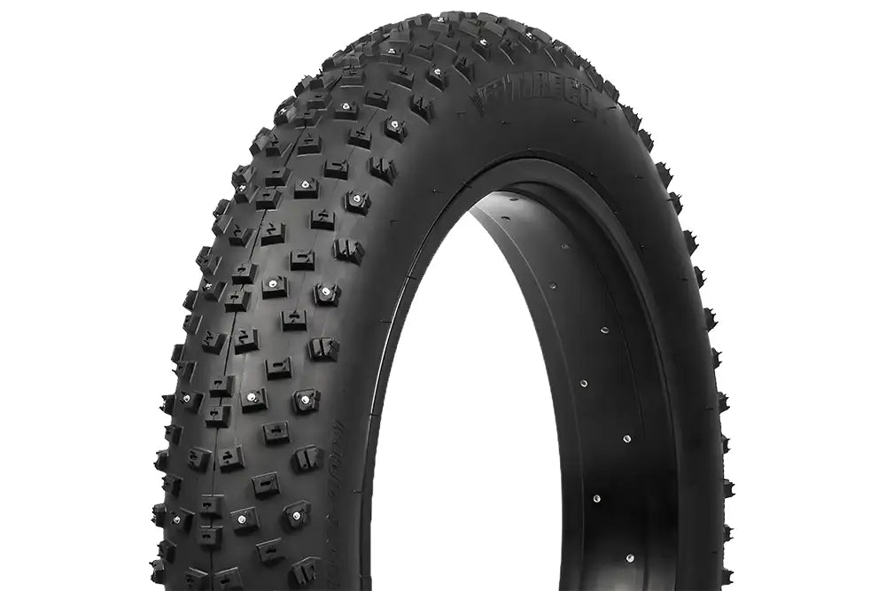 Lähikuva SÄHKÖPYÖRÄT.NET Vee Tire Snowball 20 x 4.0" fatbike nastarengas näyttää sen suuren, nastoitetun kulutuspinnan, joka tarjoaa erinomaisen lumi- ja jääpidon, ja valkoinen tausta korostaa sen karua rakennetta ja muotoilun yksityiskohtia.