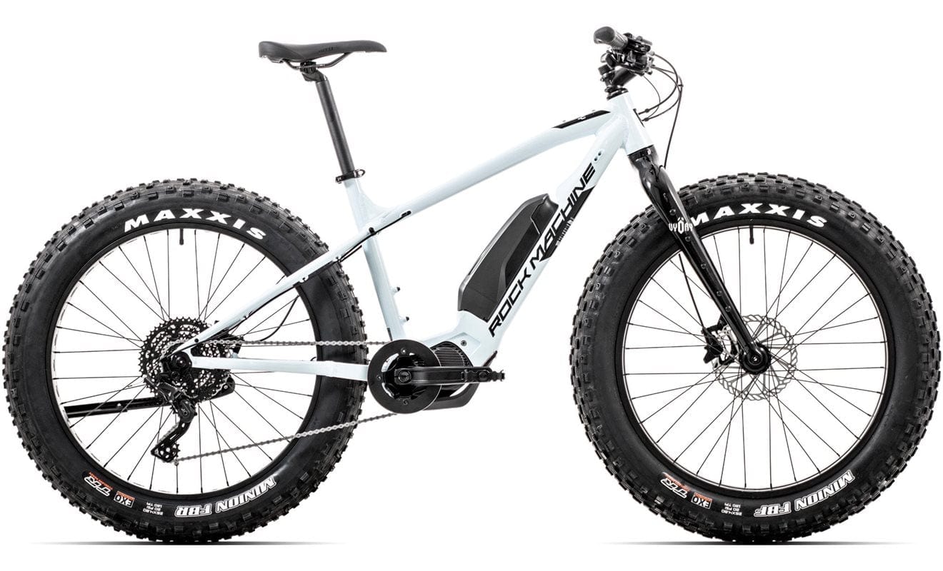 SĂHKĂPYĂRĂT.NETin Rock Machine Pyry E50R on valkoinen sĂ€hköpyörĂ€, jossa on Maxxis-renkaat, Shimano EP6 -moottori, runkoon asennettu akku ja etujousitushaarukka, joka nĂ€kyy sivulta valkoisella taustalla.