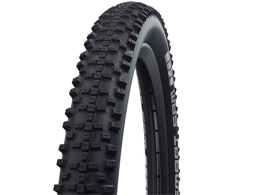 Lähikuva SCHWALBE Smart Sam 26" x 2,25" (57-559) maastopyörän rengas SÄHKÖPYÖRÄT.NET:in maastopyörän rengas, jossa on maastopidon takaava nupukkamainen kulutuspinta, kuvattuna vinossa valkoista taustaa vasten.