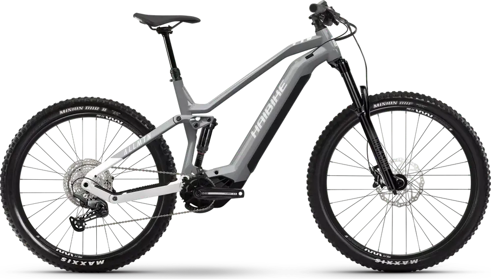 SÄHKÖPYÖRÄT.NET HAIBIKE ALLMTN 3 29/27.5" 2025 sähkömaastopyörä harmaassa ja mustassa on paksut renkaat, tukeva runko, etu- ja takajousitus sekä levyjarrut; kuvassa sivulta valkoisella pohjalla.