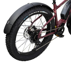 Lähikuva ruskeankeltaisen Helkama-läskipyörän takaosasta, jossa näkyy paksu kulutuspintainen rengas, vaihteet, ketju, musta poljin ja pyörän peittävä kaareva HELKAMA: FATBIKE LOKASUOJASETTI ETEEN JA TAAKSE -lokasuoja.