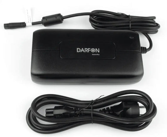 Musta SÄHKÖPYÖRÄT.NET DARFON Laturi Smart Plus 4A D-LIITIN, jossa on liitetty kaapeli ja erillinen virtajohto, jossa on vakiopistoke, molemmat siististi valkoisella pinnalla.