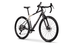 Ghost Asket Advanced on moderni gravel-pyörä, jossa on mattamusta ja beige runko, hiilikuituhaarukka, drop-ohjaustanko, paksut kulutuspintaiset renkaat, levyjarrut ja Shimano GRX 1x12-ryhmä. Rungossa näkyy Ghost-logo. Kuvassa vaaleanharmaa tausta.