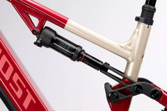 Lähikuva SÄHKÖPYÖRÄT.NETin Ghost E-ASX Essential 2026 sähkömaastopyörän rungosta, jossa korostuvat sen takajousituksen iskunvaimennin ja niveljärjestelmä tavallista taustaa vasten.