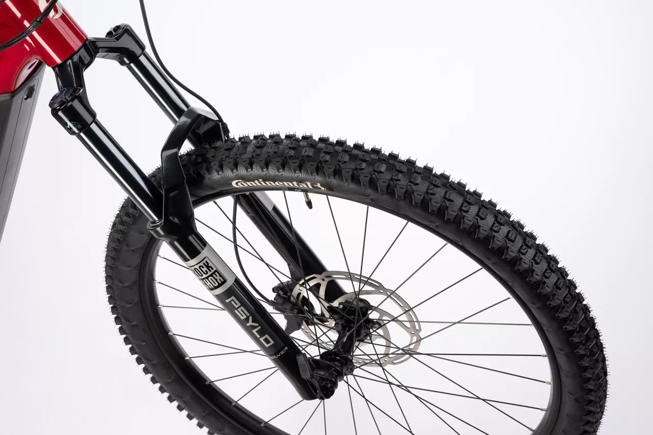 Lähikuva Ghost E-ASX Essential 2026:n etupyörästä, jossa on nuppi Continental-rengas, levyjarru ja RockShox 35 Yari -haarukka. Valkoisella pohjalla tämä SÄHKÖPYÖRÄT.NETin sähköpyörä esittelee Bosch Performance Line CX:ää ja laadukkaita komponentteja.