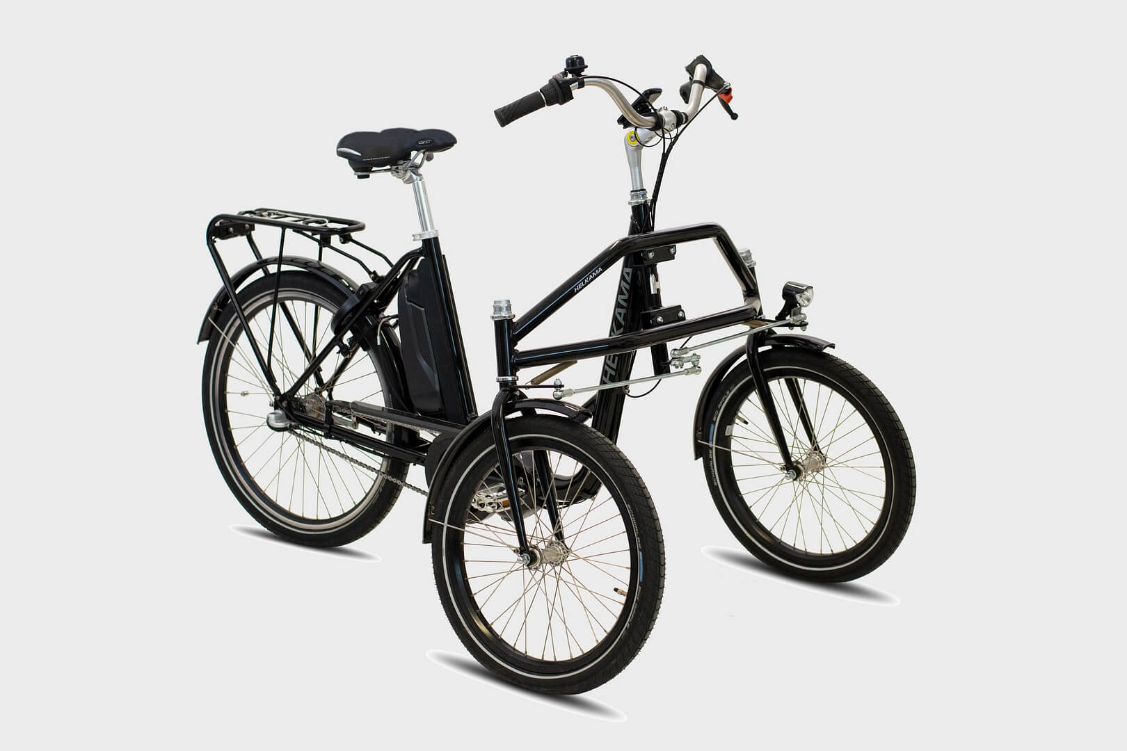 Helkama e-Trike 3v sähköpyörä kolmipyörä on musta Helkama-sähkökolmipyörä, jossa on kaksi etupyörää, tavarateline takana ja keskelle asennettu akku valkoisella pohjalla.