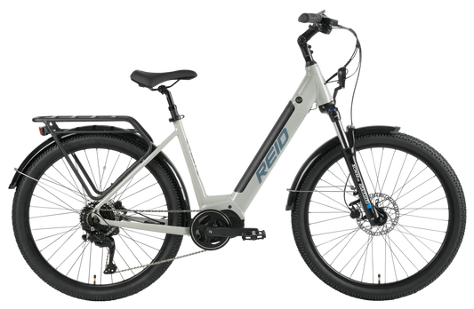 Harmaa REID E-BIKE QUEST 2.0 25 KPH L-52CM SÄHKÖPYÖRÄT.NETin harmaa REID E-BIKE QUEST 2.0 25 KPH L-52CM, jossa on 250 W:n keskikäyttöinen moottori, mustat renkaat, etujousitus, takateline, suojalevyt ja läpivientirunko, on kuvattu sivulta valkoisella pohjalla.