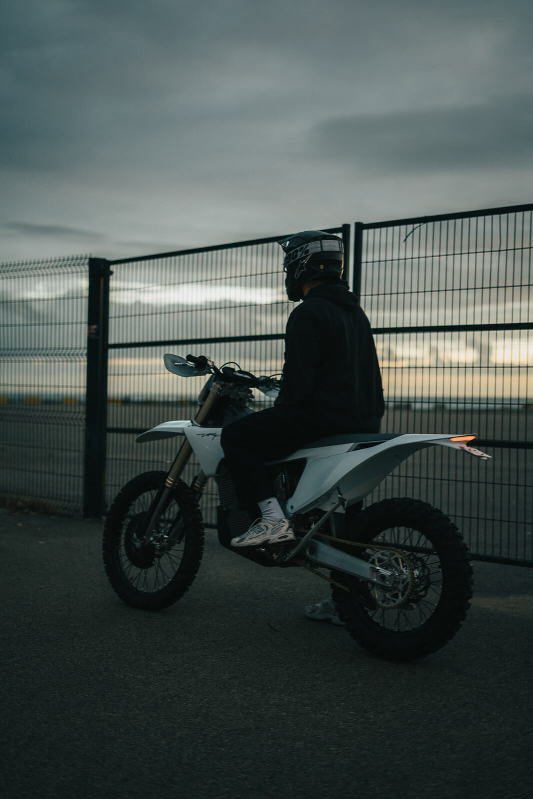 Valkoinen sähkömoottoripyörä teollisuusalueella otettu kuva